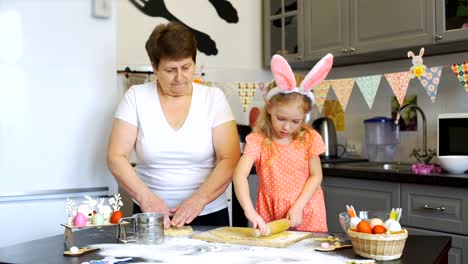 Little-Girl-rollt-einen-Teig-mit-Großmutter