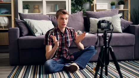 young-man-is-recording-video-for-his-online-blog--sitting-on-floor-at-home