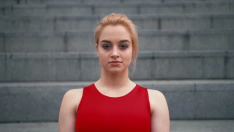 Portrait-of-plus-size-mixed-race-blond-woman-wearing-red-sportswear-looking-at-camera