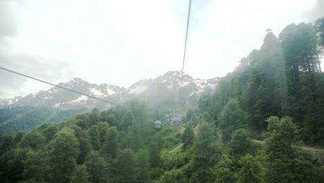 Flug-der-Kamera-über-Berge.-Aibga-Ridge.-Seilbahn-mit-Kabinen