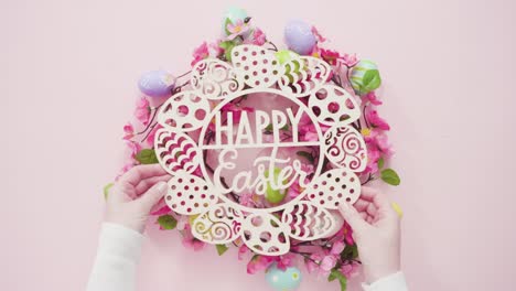 Happy-Easter-sign-and-pink-silk-flowers-on-a-pink-background.