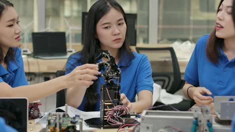 Young-electronics-engineer-team-collaborating-on-construction-of-robot-in-the-workshop.-Team-engineer-start-up-for-robot-project-together.-People-with-technology-or-innovation-concept.