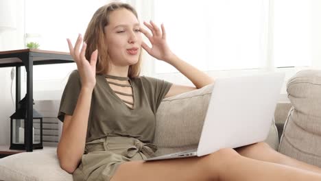 Teenage-girl-video-chatting-using-laptop-on-sofa