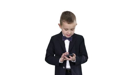 Niño-pequeño-en-traje-caminando-y-usando-el-teléfono-inteligente-sobre-fondo-blanco