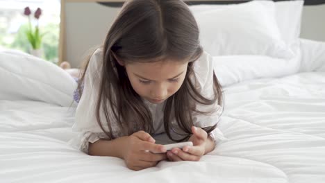 Asiatische-Mädchen-mit-Smartphone-im-Schlafzimmer