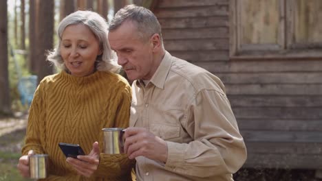 Aged-Couple-near-Wooden-House-in-Forest