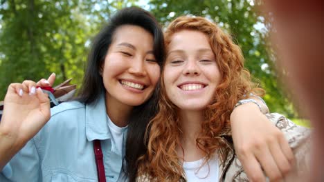 Slow-motion-portrait-of-happy-women-taking-selfie-outdoors-with-shopping-bags