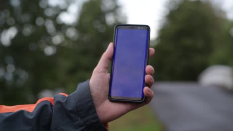 Hand-von-jungen-Mann-mit-Telefon-im-Freien