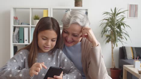 Caucasian-Grandmother-and-Grandchild-Using-Smartphone