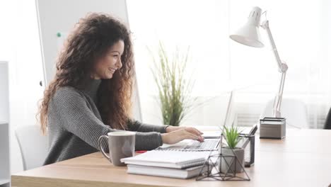 Smiling-businesswoman-working-on-laptop