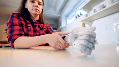 Young-woman-puts-on-a-bionic-hand-prosthesis,-close-up.