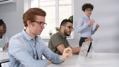 Profesora-profesora-enseñando-a-estudiantes-con-dispositivos-de-pantalla-táctil-futurista