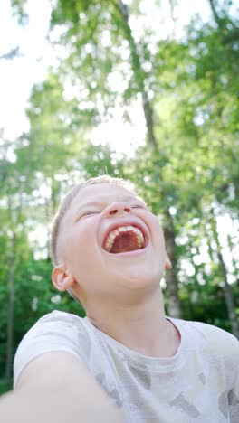 Beautiful-Handsome-Child-Taking-Selfies-on-a-Smartphone-and-Laughing.-One-Boy-on-a-facetime-videocall-with-Family-Members.-Uncontrollable-Toothy-Laughter.-Video-with-Vertical-Screen-Orientation-9:16