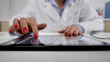 female-doctor-working-at-her-desk-analysing-x-rays-mri-brain-on-tablet-computer