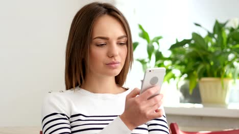 Beautiful-Young-Woman-Browsing-Smartphone-in-Office