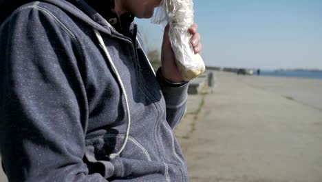 Close-up-on-a-disabled-man-in-a-wheelchair-eating-a-doner-kebab,-portrait-lonesome-male