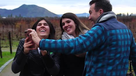 Padre-e-hija-riendo-mientras-se-mira-en-el-smartphone