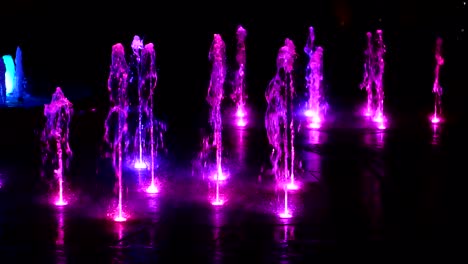 Fountain-illuminated-at-night-with-purple