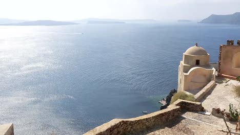 Rippled-sunlit-sea-viewed-from-mountain-top,-church-dome-and-fortress-remains