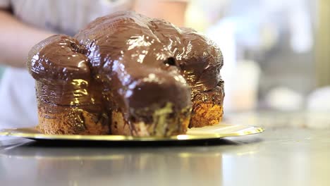 Pastry-Chef-Hände-glasiert-Osterkuchen-süßes-Brot-mit-Schokolade,-Nahaufnahme-auf-der-Arbeitsplatte-in-der-Konditorei