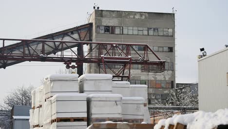 Building-and-construction-materials-for-sale-stored-on-metal-shelves-outdoors-in-a-warehouse-yard-together-with-wooden-pallets-for-loading,-distribution-and-storage