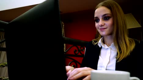 Young-business-lady-sitting-on-a-laptop-is-gaining-text