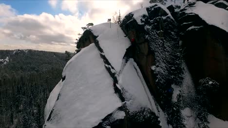 Luftaufnahme-von-einem-Kletterer-Klettern-steile-Klippen-bei-einem-sonnigen-Wintertag.