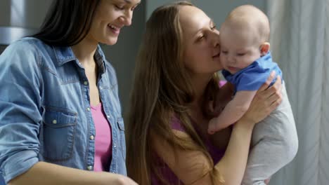 Frau-mit-Baby-im-Chat-mit-Partnerin-Abendessen