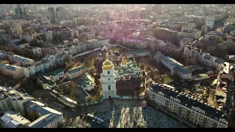 Ve-el-ojo-de-un-pájaro,-video-panorámico-de-los-aviones-no-tripulados-en-FullHD-a-la-Catedral-de-Santa-Sofía,-la-Plaza-Sofiyivska-en-la-ciudad-de-Kiev,-Ucrania.-Personas-en-la-plaza-en-los-días-de-semana-Santa.