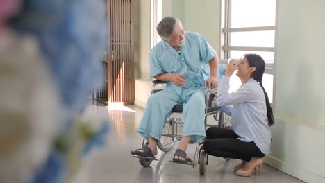 Mujeres-asiáticas-tranquilizar-y-animar-a-los-pacientes-ancianos-en-silla-de-ruedas