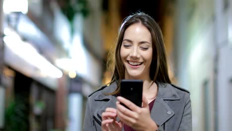 Woman-walking-using-a-smart-phone-in-the-night