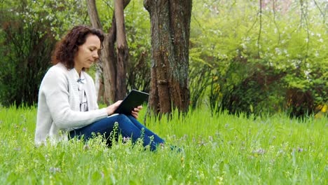 Mädchen-im-Park-mit-einem-Tablet.