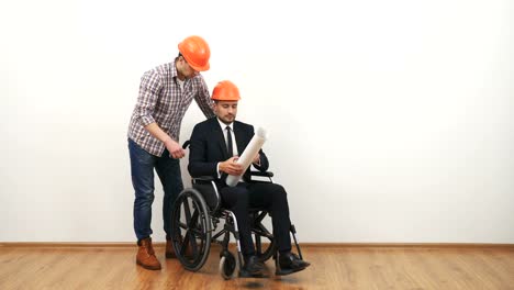 The-businessman-on-the-wheelchair-and-a-engineer-dicuss-with-a-drawing