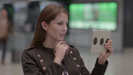 Cheerful-young-Caucasian-woman-surfing-the-internet-on-a-digital-tablet