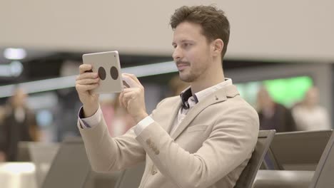 Caucasian-employee-working-online-and-mobile-at-train-station-with-digital-tablet