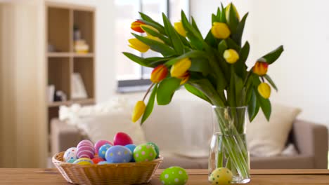 huevos-de-Pascua-en-cesta-y-tulipán-flores-en-casa