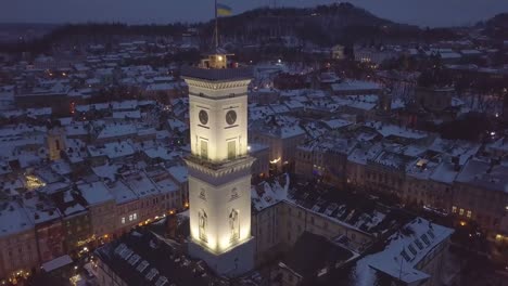 Lviv,-Ucrania---25-de-diciembre-de-2018.-Tiro-de-Arial.-Invierno.-Calle-plaza-Rynok.-Feria-de-Navidad.-Ayuntamiento-de-Lvov,-Consejo-de-la-ciudad.-Personas-están-caminando-en-el-centro-de-la-ciudad.-Adornos-navideños-y-luces.-Noche