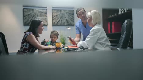 Médico-y-enfermeras-trabajando-en-oficina-del-Hospital-con-la-madre-del-niño