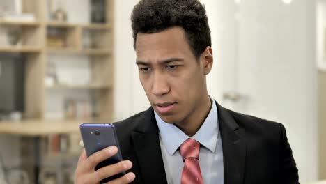 African-Businessman-Browsing-Smartphone