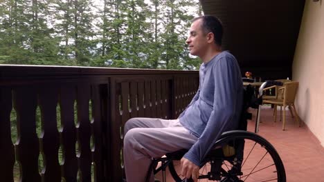 Young-man-in-wheelchair-relaxing-on-terrace