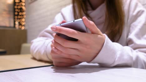 Woman-is-typing-a-message-on-mobile-phone,-hands-close-up.