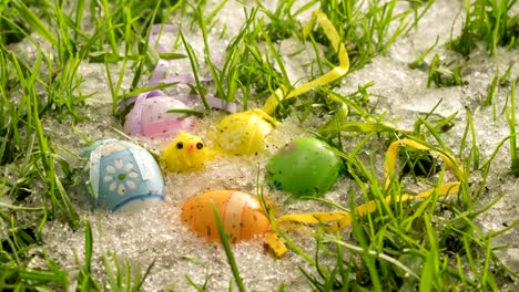 Snow-melt-in-green-grassy-meadow-with-colorful-painted-Easter-eggs-and-cute-chick-decoration-Time-lapse