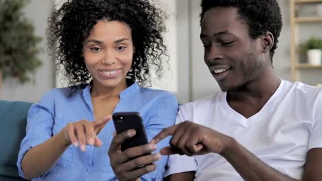 Pareja-africana-compartiendo-información-en-smartphone