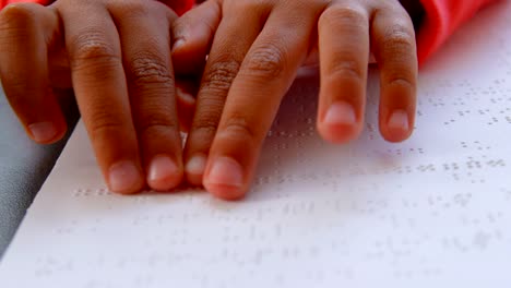 Nahaufnahme-der-blinden-asiatischen-Schülerinnen-und-Schüler,-die-ein-Braille-Buch-im-Klassenzimmer-der-Schule-4k-lesen