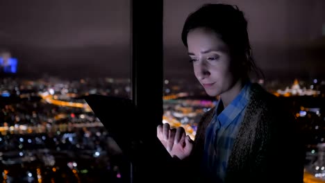 Frau-mit-schwarzem-digitalen-Tablet-in-der-Nacht