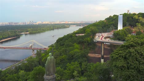 Aerial-view-of-the-Monument-to-Vladimir-the-Great,-the-Pedestrian-Bridge-and-the-Dnieper-River,-Kiev