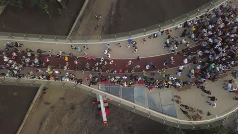 Eine-Menschenmenge-auf-einer-Fußgängerbrücke-ist-am-Frühlingsabend-zu-sehen.-Luftaufnahme.-Eine-neue-Fahrrad-Fußgängerbrücke-im-Zentrum-der-Hauptstadt-der-Ukraine,-der-Stadt-Kiew.-Ausflüge-und-Spaziergänge-für-Touristen