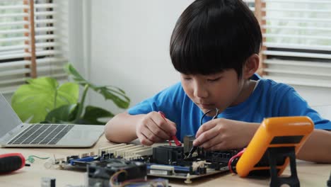 Boy-tratar-de-arreglar-la-tabla-de-computadoras-en-el-Club-de-Ciencias-escolares.-Proyecto-para-Club-de-ingeniería-en-la-escuela.-Personas-con-concepto-tecnológico.