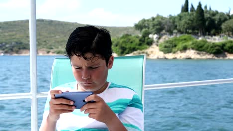 Junge-auf-dem-Boot-mit-dem-Smartphone