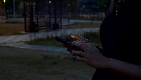 Hands-of-young-woman-typing-on-mobile-phone